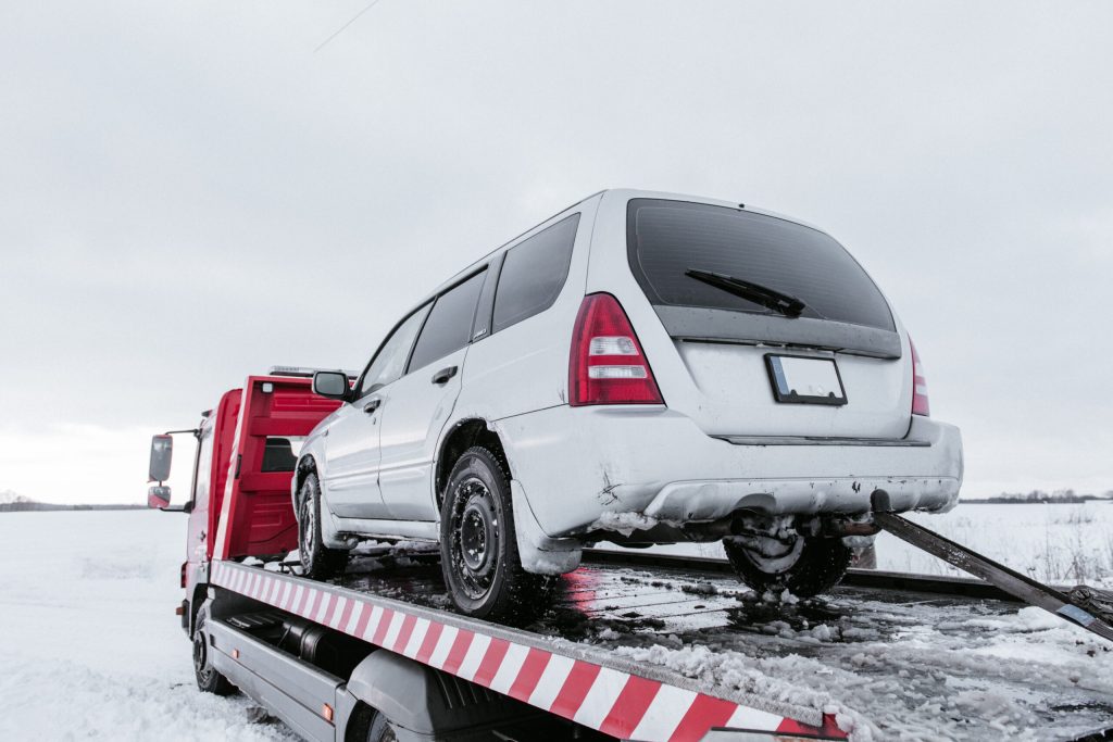 Dépannage voiture 24h/24 : véhicule transporté sur dépanneuse sur route enneigée